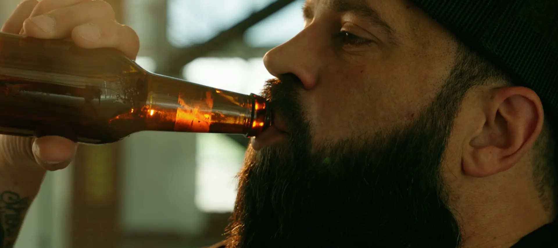 Close-up of Jeff drinking from a beer bottle